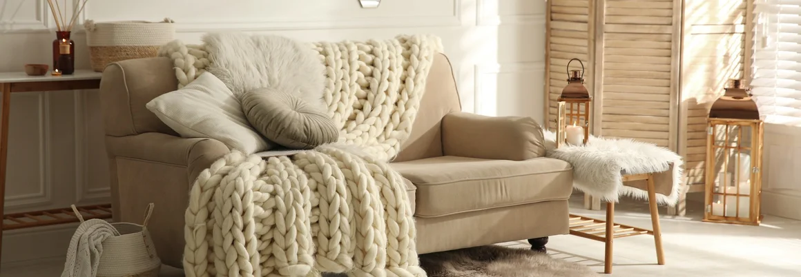 Gemütlicher Sessel mit Strickdecke